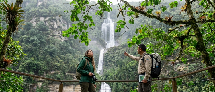 Travelers with a local guide observing the waterfall