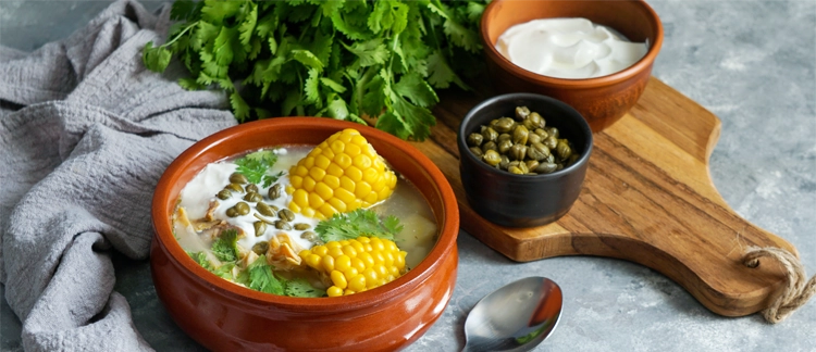 Traditional Colombian ajiaco served with capers and cream