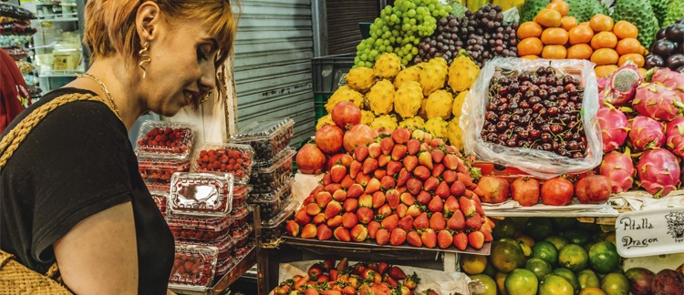 Traveler exploring exotic Colombian fruits at Paloquemao
